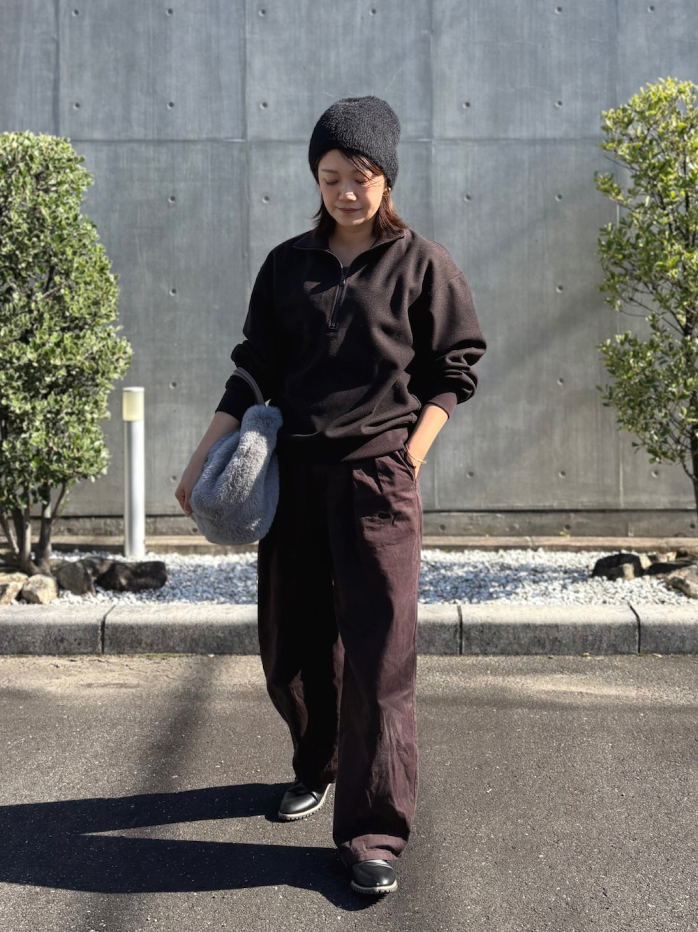 グレー系のショルダーバッグ、ブラック系のローファー、ブラウン系のスウェットを着用したレディースの秋コーディネートの1枚目の写真