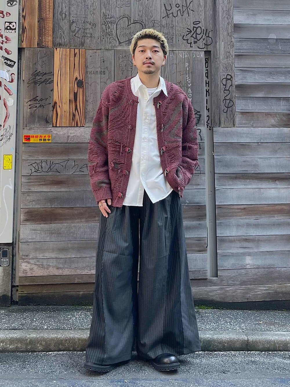 ブラック系のその他シューズ、ブラック系のその他パンツ、レッド系のカーディガン/ボレロを着用したメンズの冬コーディネートの1枚目の写真