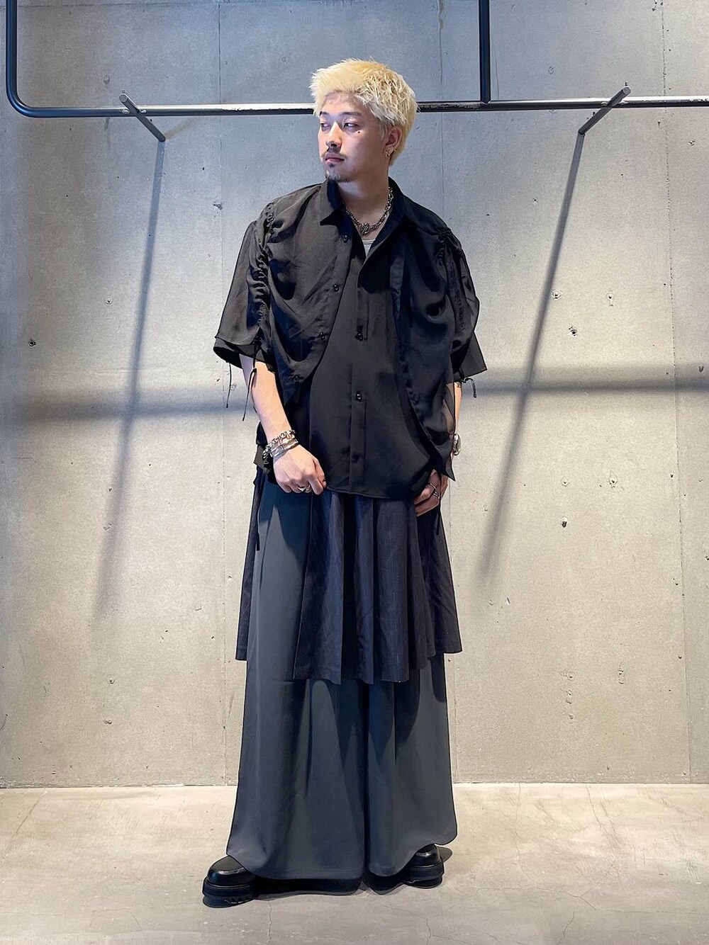 グレー系のスラックス、ブラック系のドレスシューズ、ブラック系のシャツ/ブラウスを着用したメンズの夏コーディネートの1枚目の写真