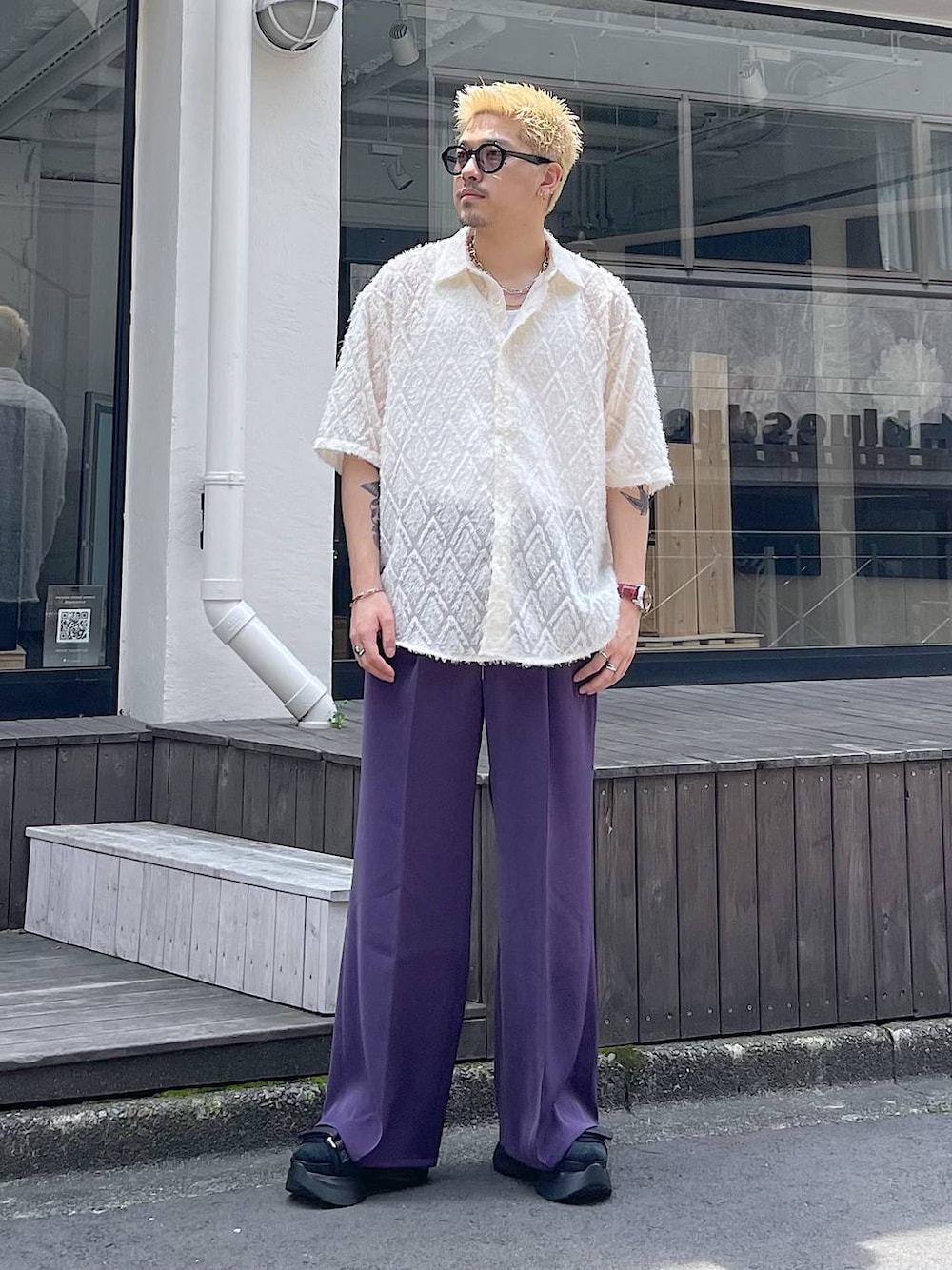 パープル系のスラックス、ブラック系のサンダル、ホワイト系のタンクトップを着用したメンズの夏コーディネートの1枚目の写真