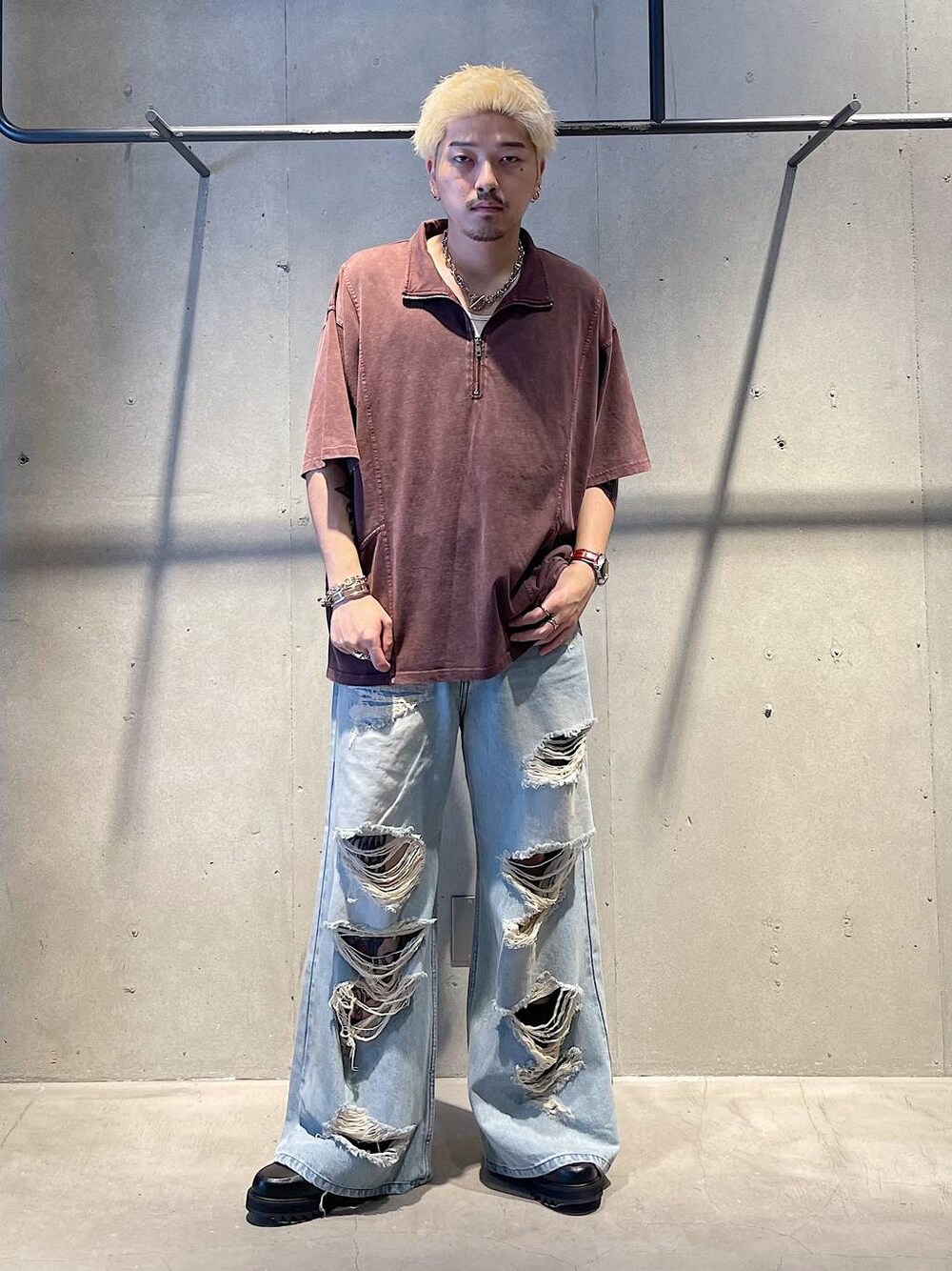 ブルー系のデニムパンツ、ブラック系のドレスシューズ、レッド系のTシャツ/カットソーを着用したメンズの秋コーディネートの1枚目の写真