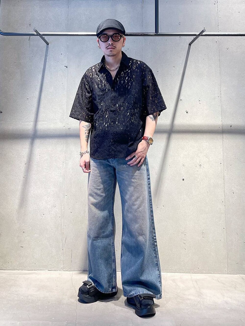 ブラック系のサンダル、パープル系のデニムパンツ、ホワイト系のタンクトップを着用したメンズの夏コーディネートの1枚目の写真