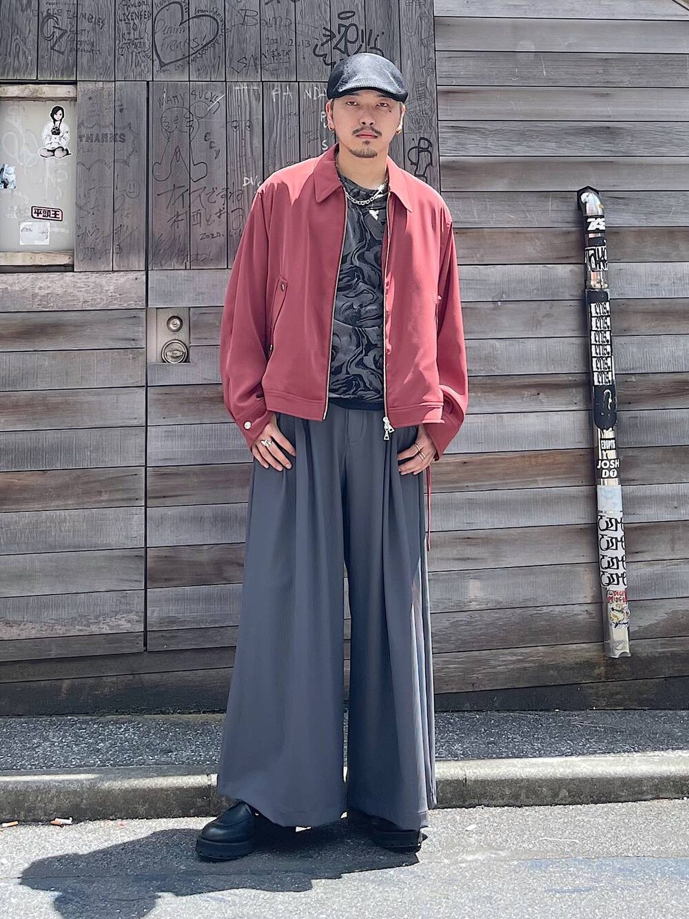 オレンジ系のブルゾン、グレー系のTシャツ/カットソー、グレー系のスラックスを着用したメンズの秋コーディネートの1枚目の写真