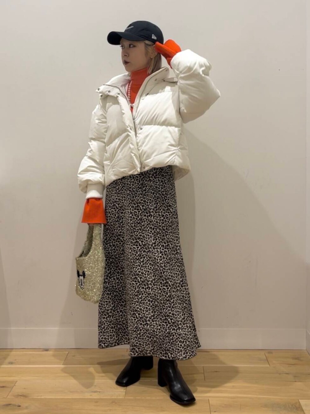 ホワイト系のダウンジャケット/コート、ブラック系のブーツ、ゴールド系のトートバッグを着用したレディースの秋コーディネートの1枚目の写真