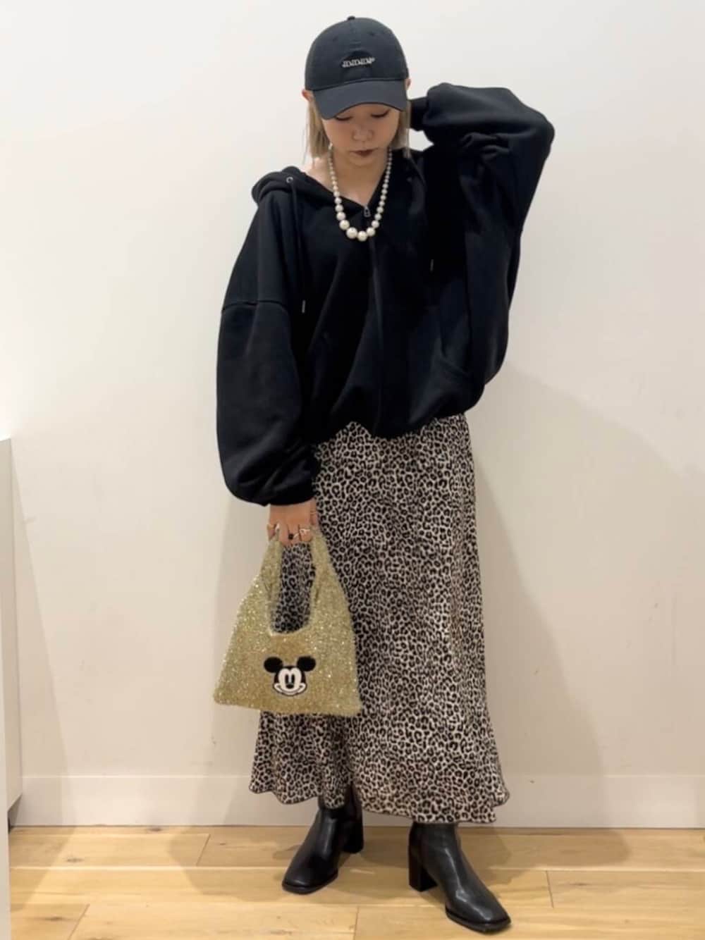 ブラック系のブーツ、ゴールド系のトートバッグ、ブラウン系のスカートを着用したレディースの秋コーディネートの1枚目の写真