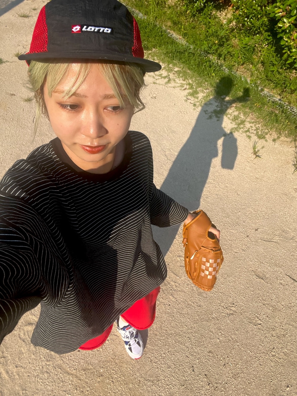 ブラック系のTシャツ/カットソー、レッド系のキャップを着用したレディースの秋コーディネートの1枚目の写真