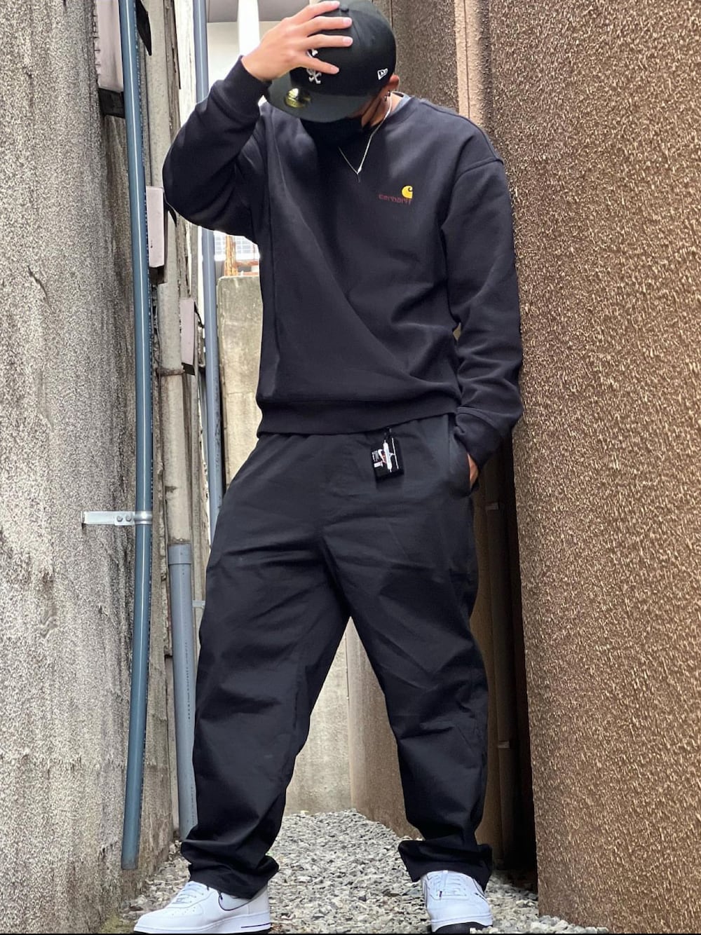 ブラック系のスウェット、ホワイト系のシューズ、ブラック系のカーゴパンツを着用したメンズの秋コーディネートの1枚目の写真