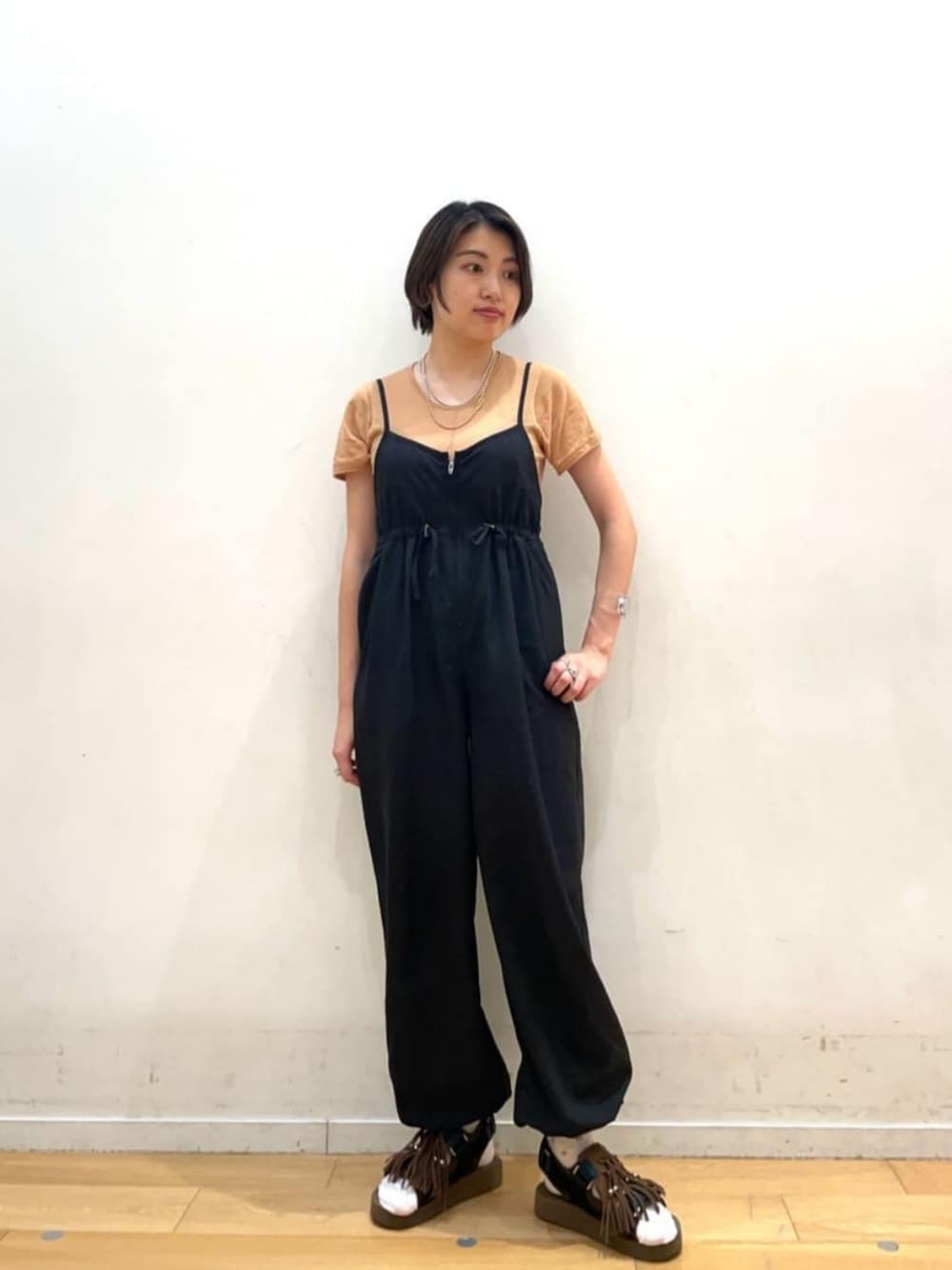 ブラック系のサロペット/オーバーオール、ベージュ系のニット/セーターを着用したレディースの夏コーディネートの1枚目の写真