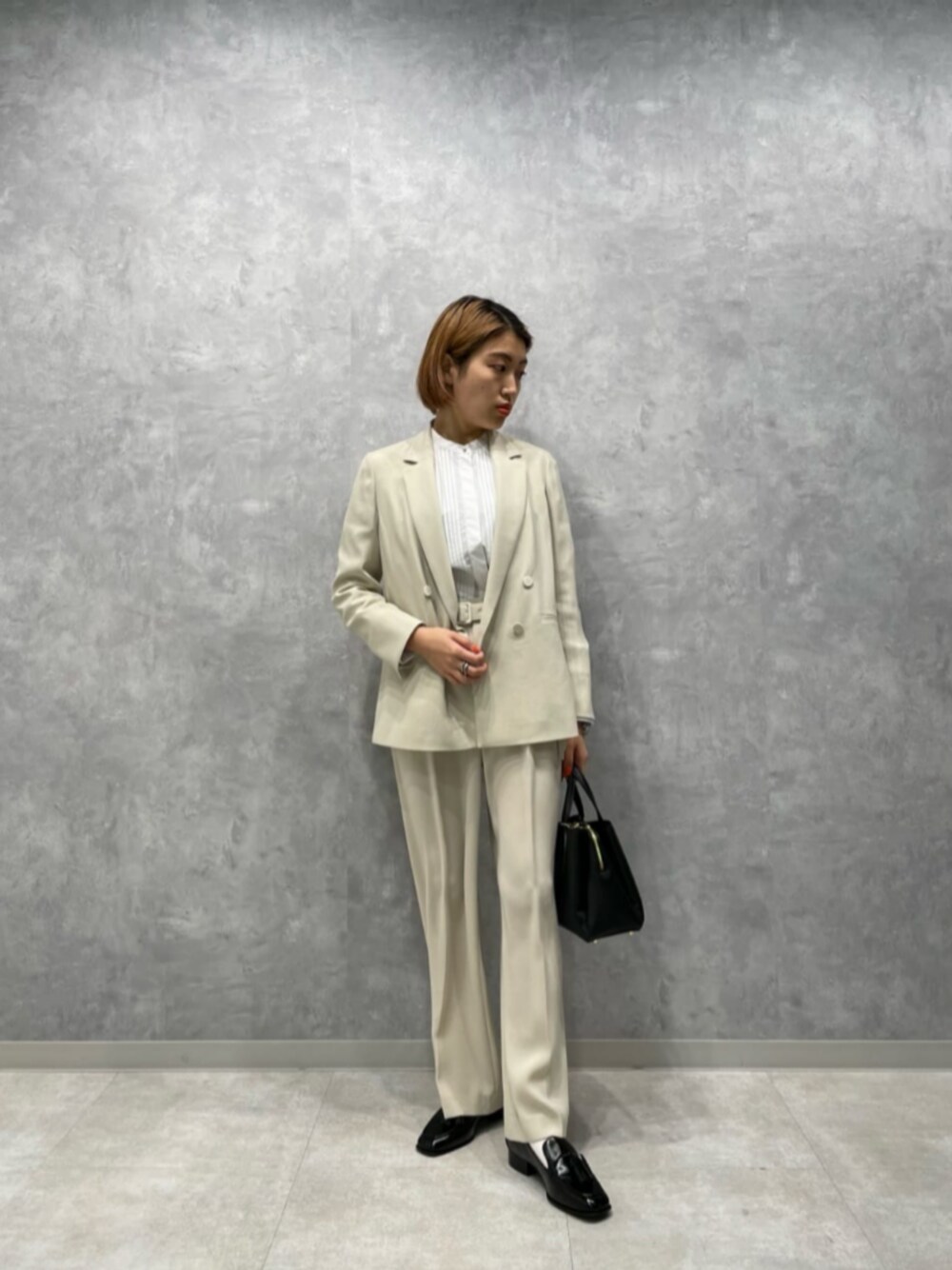 ホワイト系のシャツ/ブラウス、ブラック系のその他シューズ、ブラック系のハンドバッグを着用したレディースの冬コーディネートの1枚目の写真