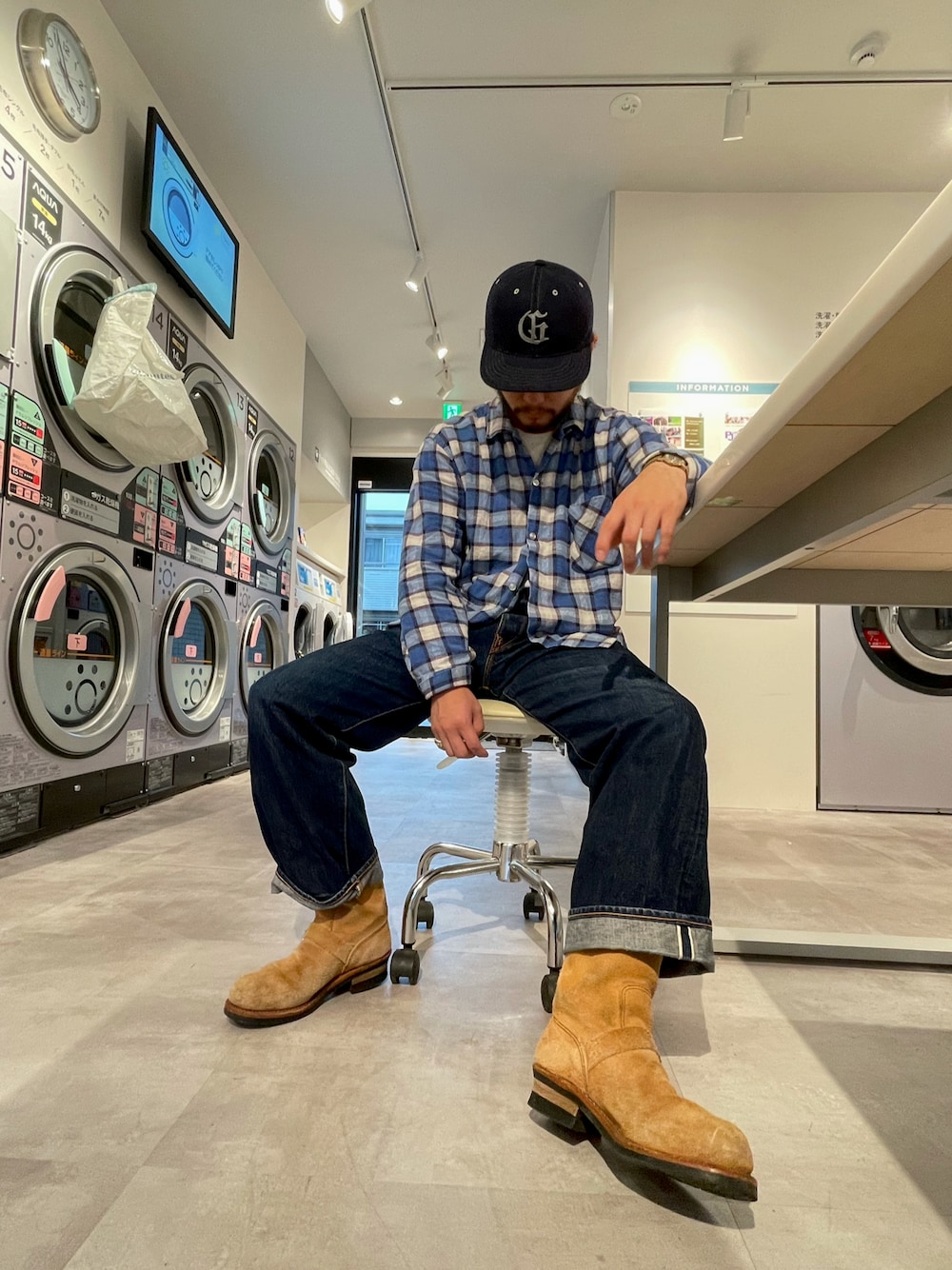 ブルー系のシャツ/ブラウス、ベージュ系のブーツ、ブルー系のキャップを着用したメンズの秋コーディネートの1枚目の写真