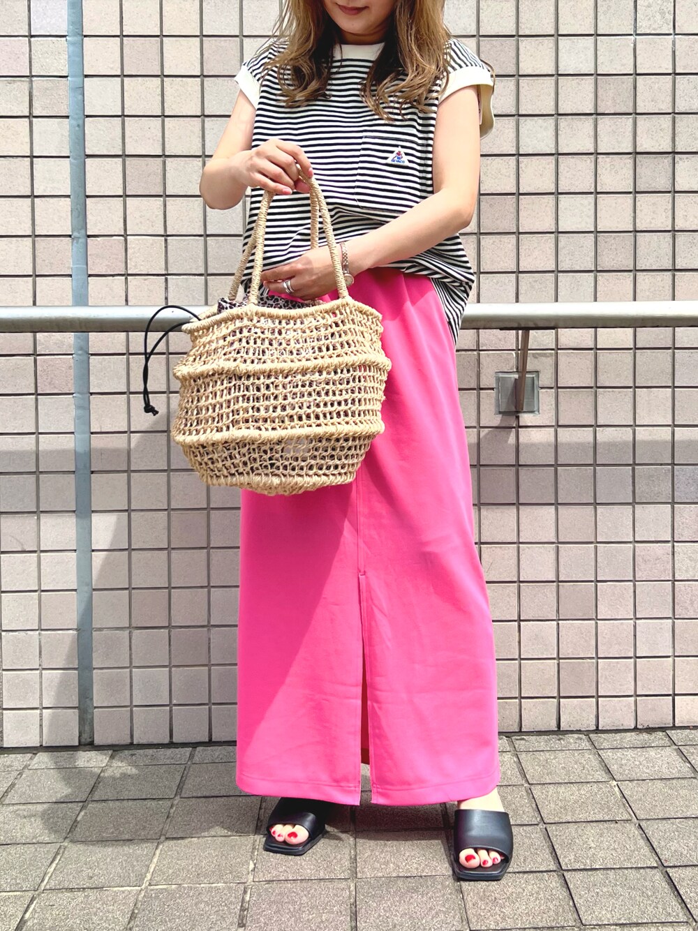 その他のかごバッグ、ピンク系のスカート、ブラック系のTシャツ/カットソーを着用したレディースの春コーディネートの1枚目の写真