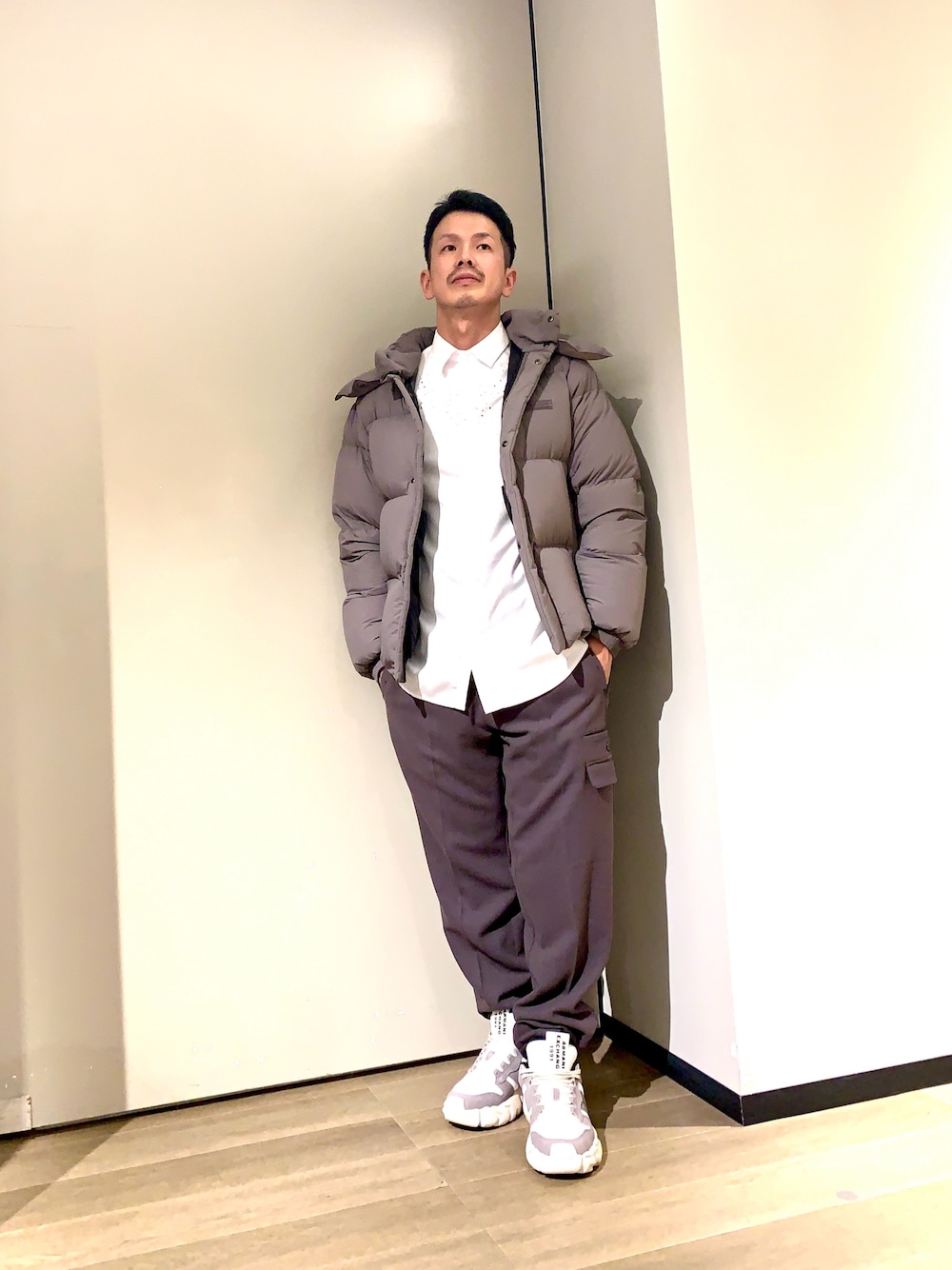 グレー系のカーゴパンツ、ブラック系のスニーカー、ホワイト系のシャツ/ブラウスを着用したメンズの冬コーディネートの1枚目の写真