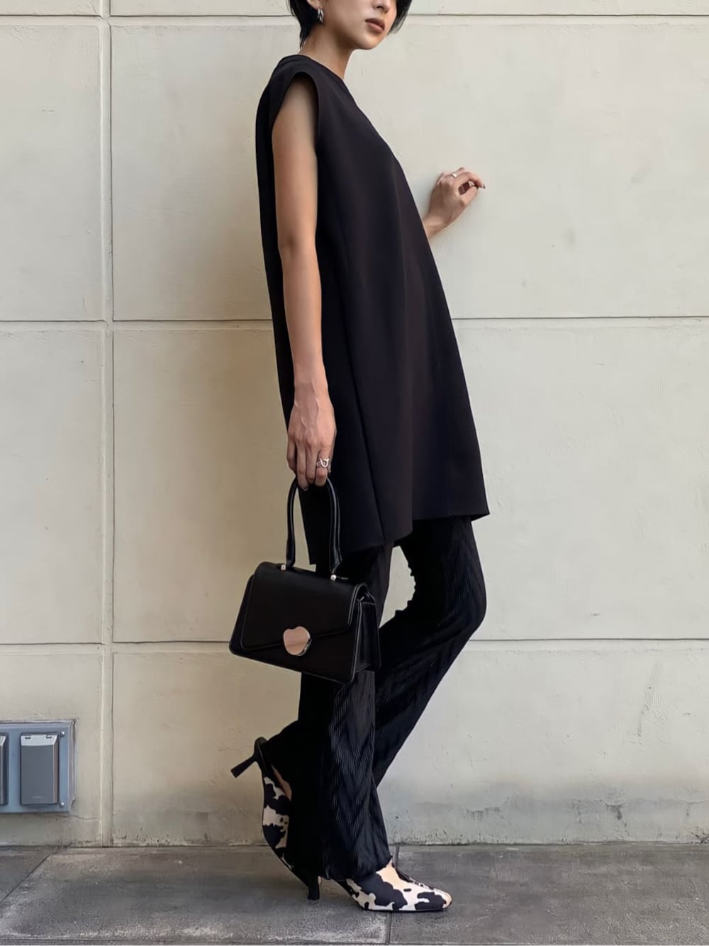 ブラック系のハンドバッグ、その他のパンプス、ブラック系のワンピースを着用したレディースの夏コーディネートの1枚目の写真