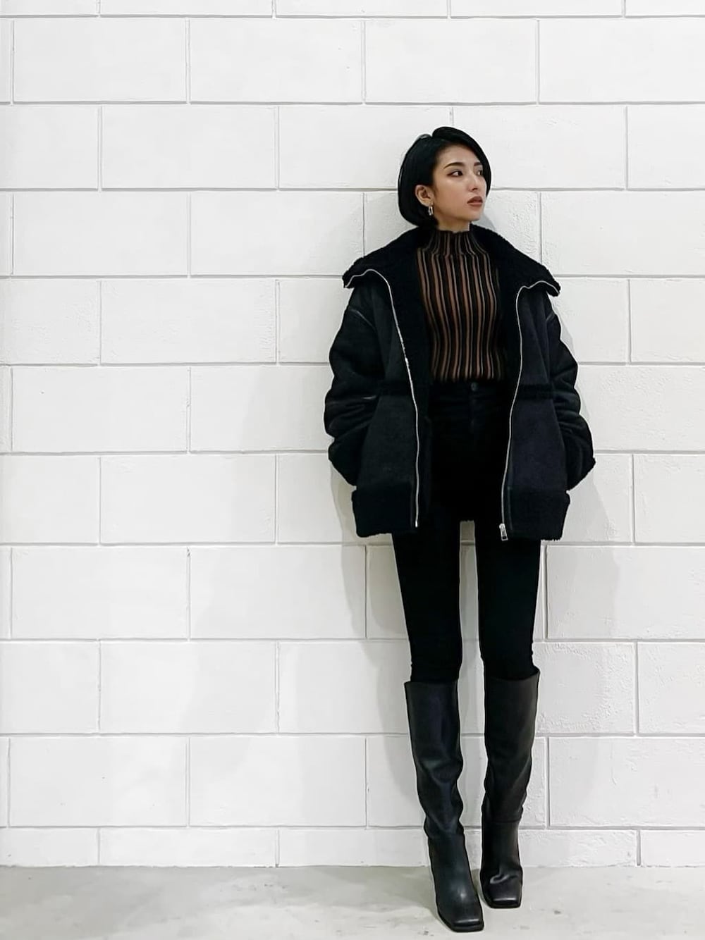 ブラック系のムートンコート、ブラック系のブーツ、ブラック系のデニムパンツを着用したレディースの冬コーディネートの1枚目の写真