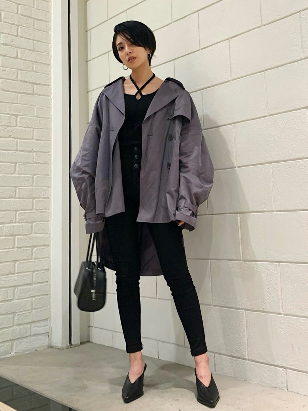パープル系のトレンチコート、ブラック系のハンドバッグ、ブラック系のサンダルを着用したレディースの春コーディネートの1枚目の写真