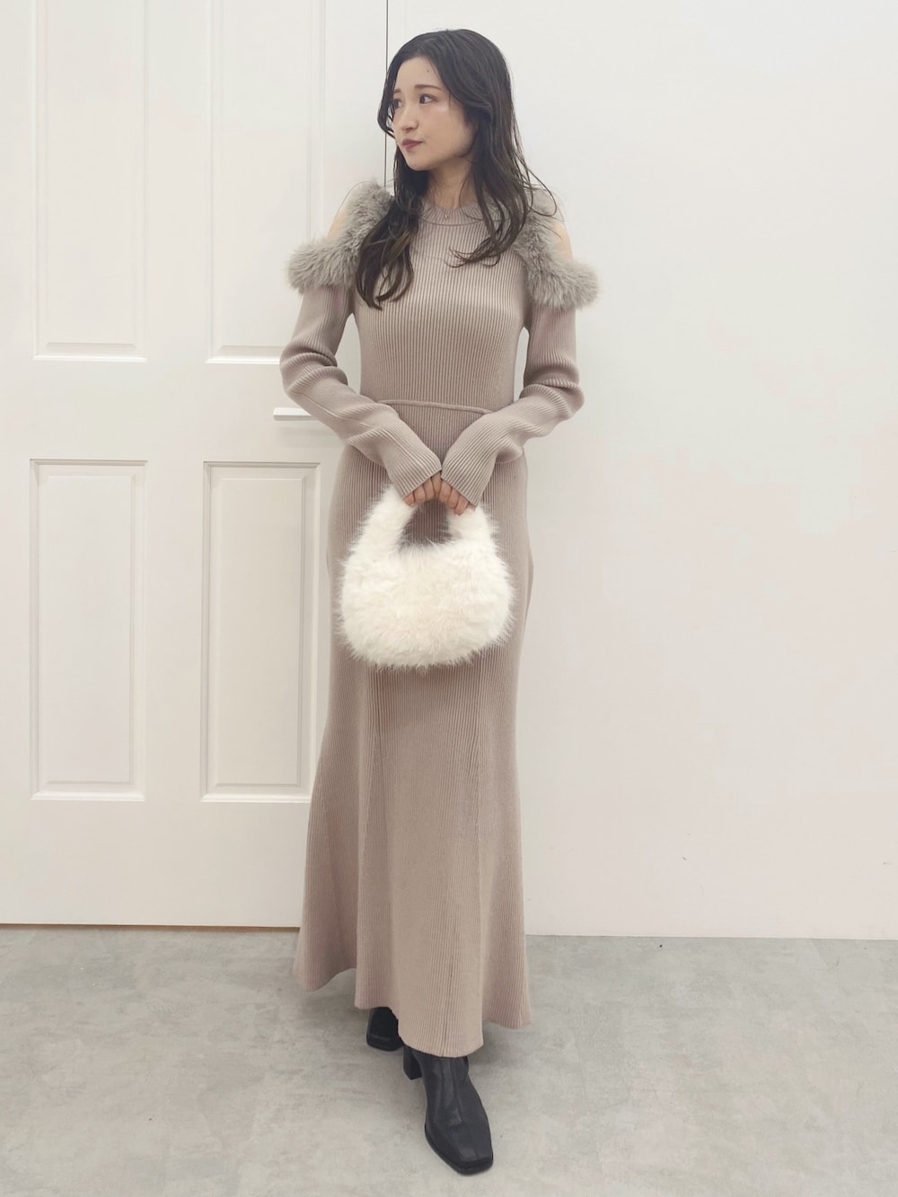 ホワイト系のハンドバッグ、ブラック系のブーツ、ベージュ系のワンピースを着用したレディースの秋コーディネートの1枚目の写真