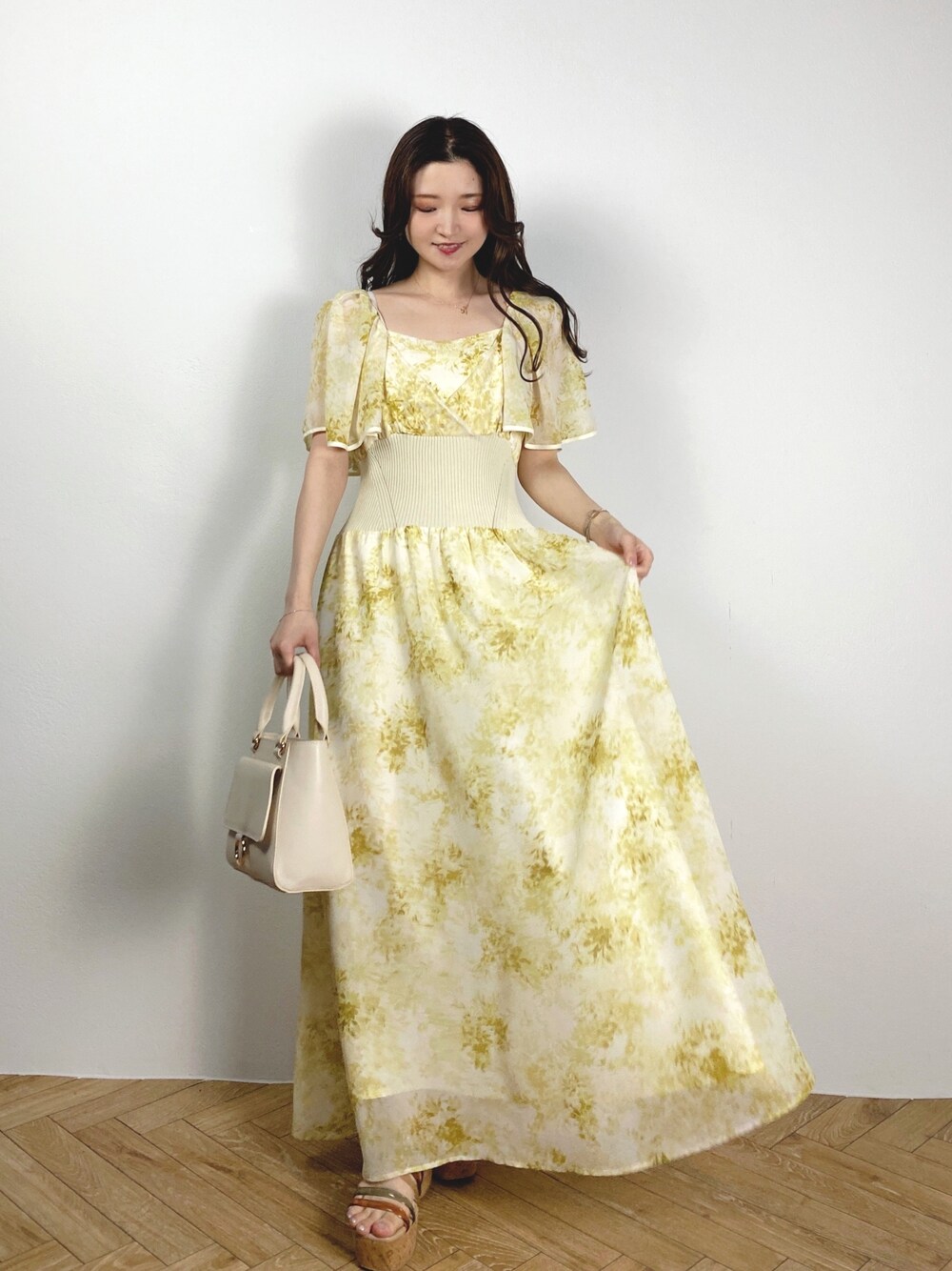 ホワイト系のハンドバッグ、その他のサンダル、イエロー系のワンピースを着用したレディースの夏コーディネートの1枚目の写真