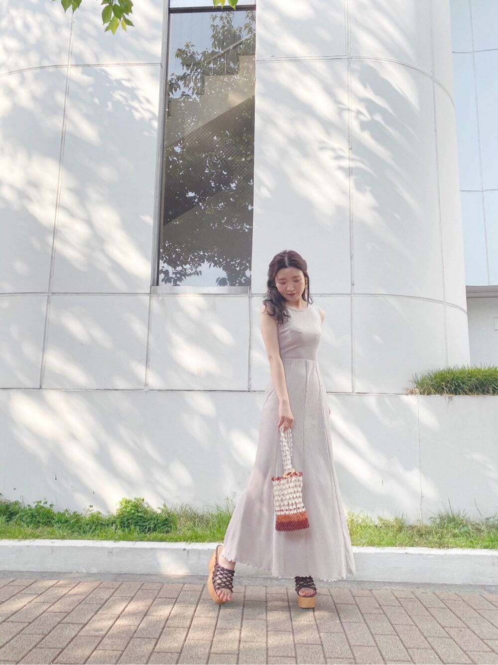 ブラウン系のサンダル、その他のハンドバッグを着用したレディースの春コーディネートの1枚目の写真