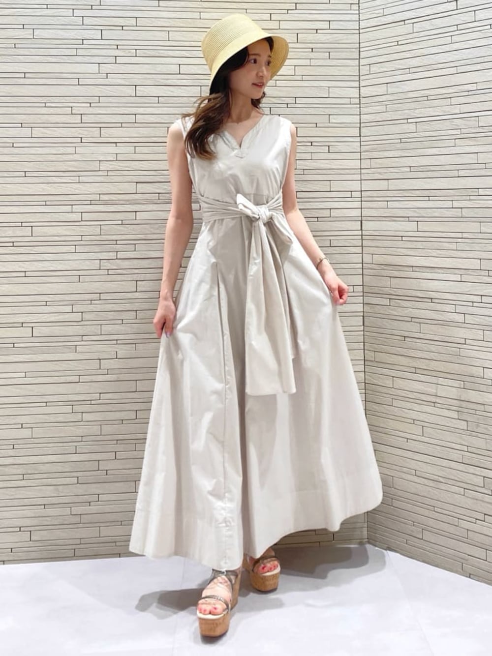 ホワイト系のワンピース、ベージュ系のハットを着用したレディースの春コーディネートの1枚目の写真