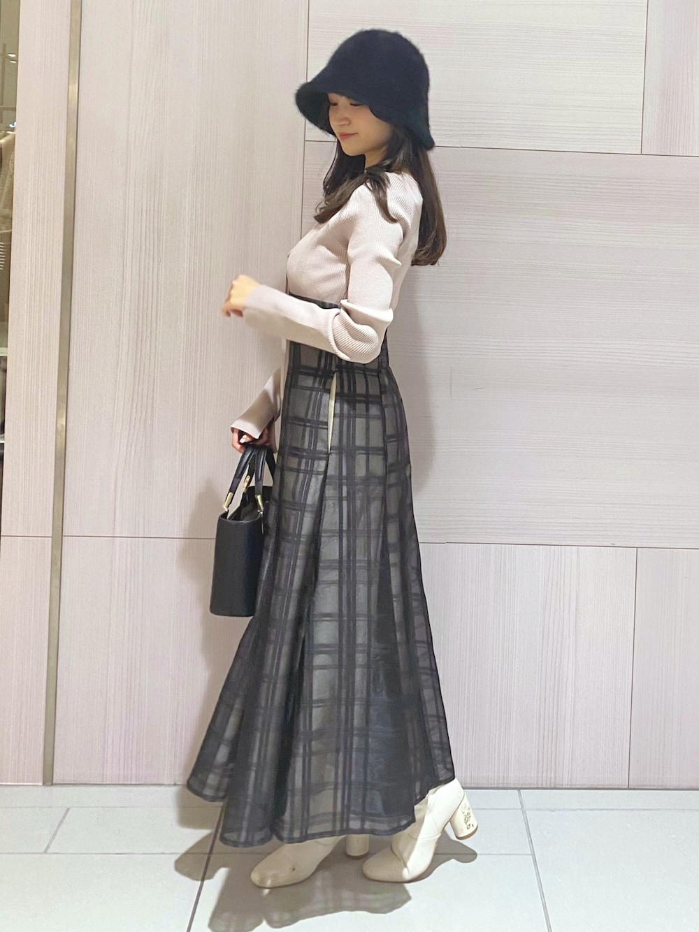 ピンク系のワンピース、ブラック系のハンドバッグ、ホワイト系のブーツを着用したレディースの秋コーディネートの1枚目の写真