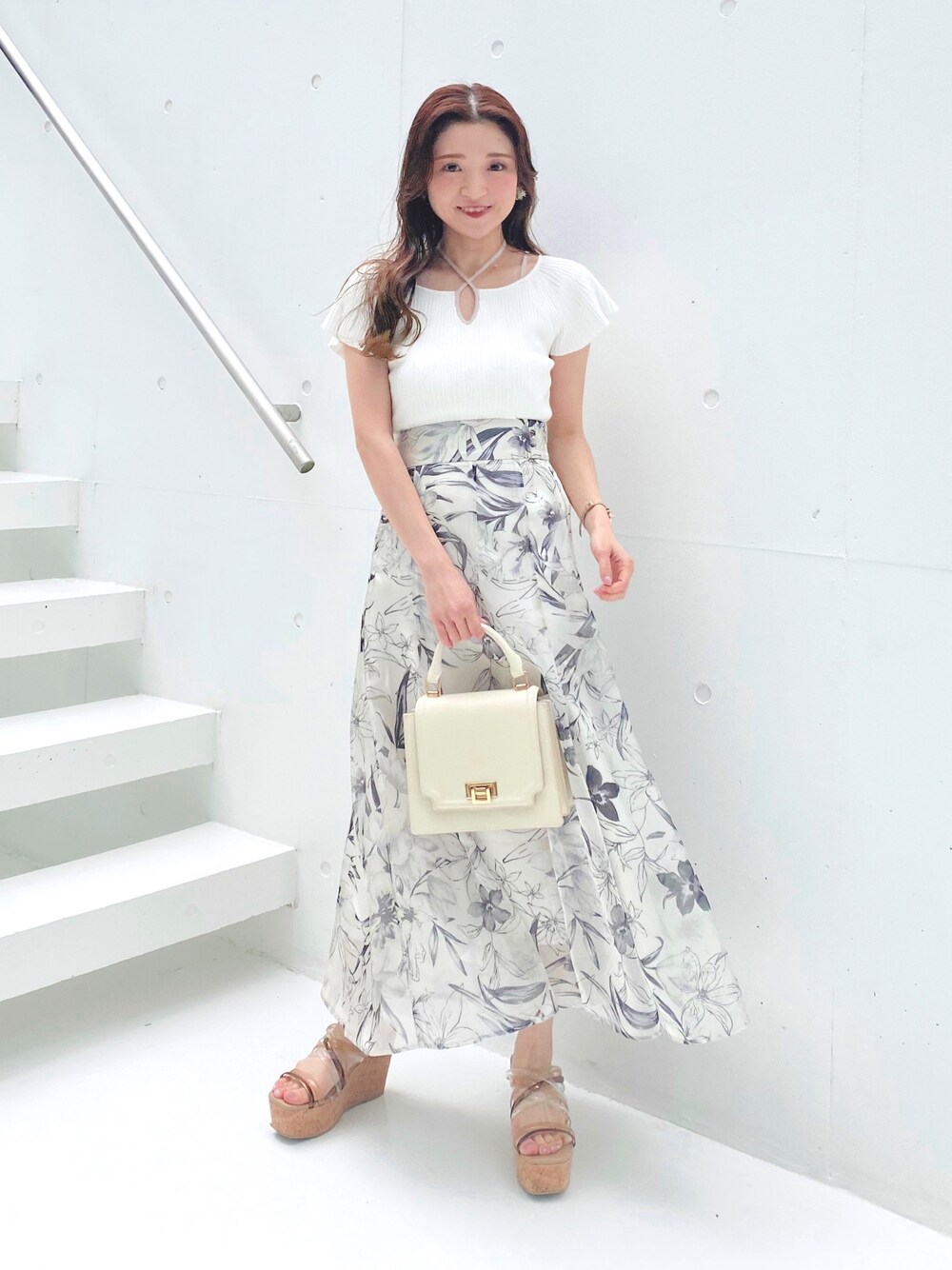 ホワイト系のニット/セーター、ブラウン系のサンダル、ホワイト系のハンドバッグを着用したレディースの夏コーディネートの1枚目の写真