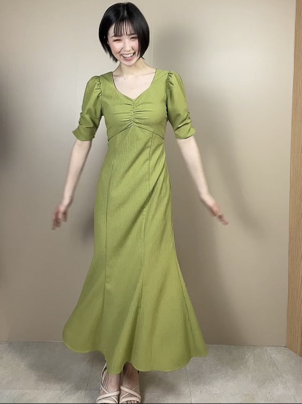 ホワイト系のサンダル、グリーン系のワンピースを着用したレディースの春コーディネートの1枚目の写真