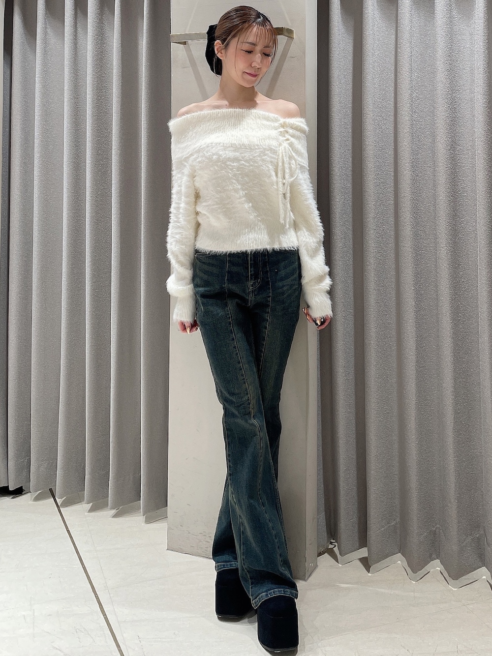 ホワイト系のニット/セーター、ブルー系のデニムパンツ、ブラック系のブーツを着用したレディースの秋コーディネートの1枚目の写真