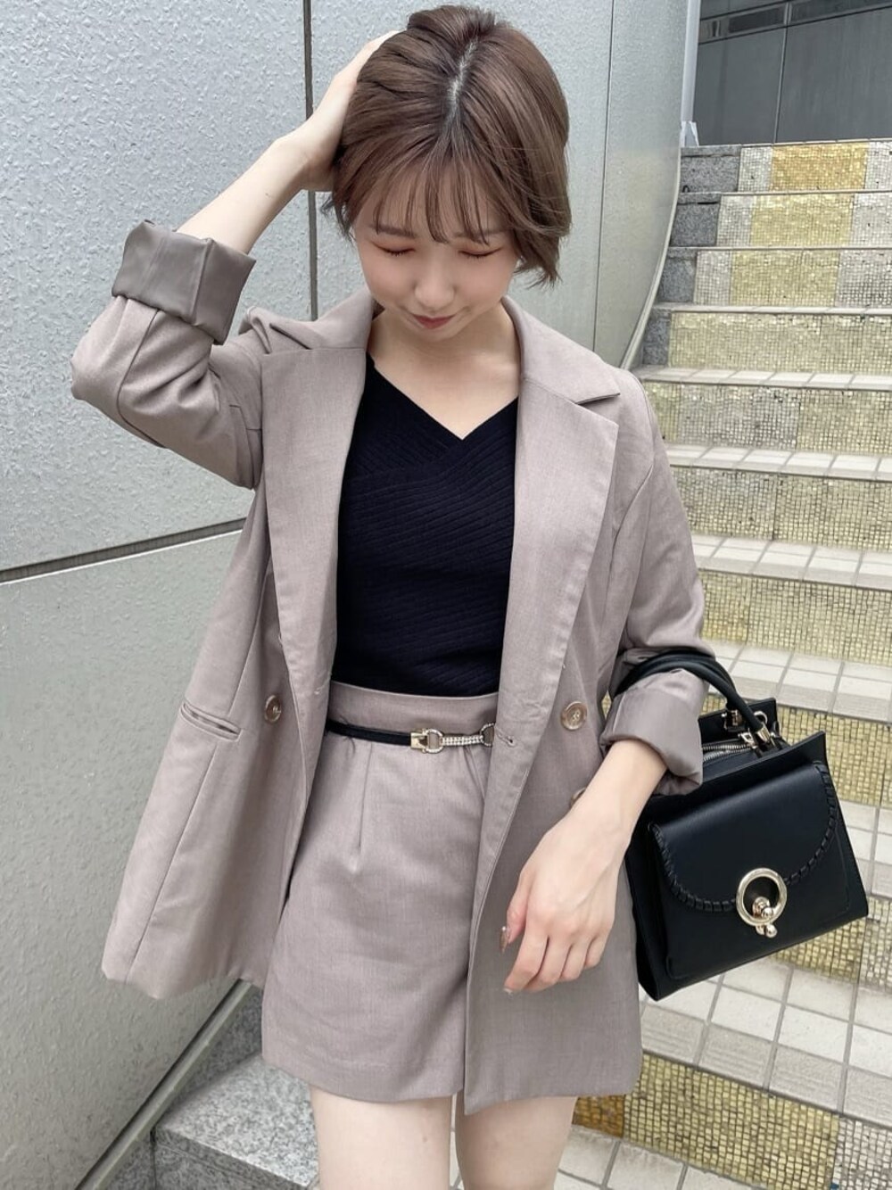 ベージュ系のテーラードジャケット、ブラック系のハンドバッグ、ベージュ系のその他パンツを着用したレディースの夏コーディネートの1枚目の写真