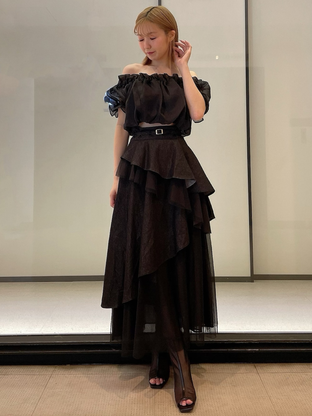 ブラック系のシャツ/ブラウス、ブラック系のデニムスカート、ブラック系のブーツを着用したレディースの夏コーディネートの1枚目の写真