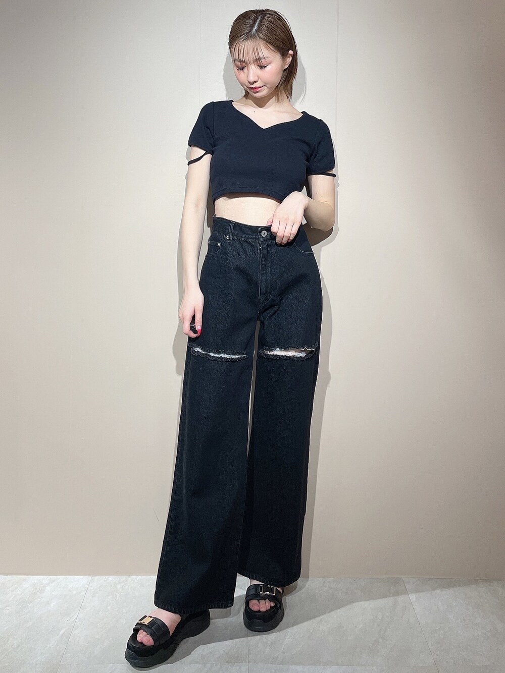 ブラック系のTシャツ/カットソー、ブラック系のデニムパンツ、ブラック系のサンダルを着用したレディースの春コーディネートの1枚目の写真