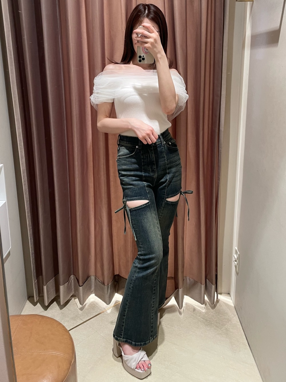 ホワイト系のニット/セーター、ブルー系のデニムパンツ、ベージュ系のサンダルを着用したレディースの春コーディネートの1枚目の写真