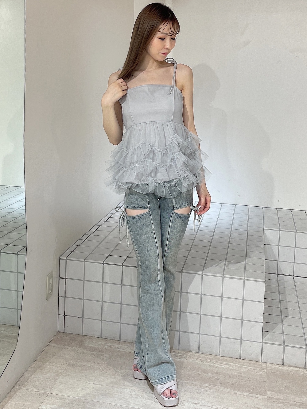 ブルー系のキャミソール、ブルー系のデニムパンツ、ベージュ系のサンダルを着用したレディースの夏コーディネートの1枚目の写真