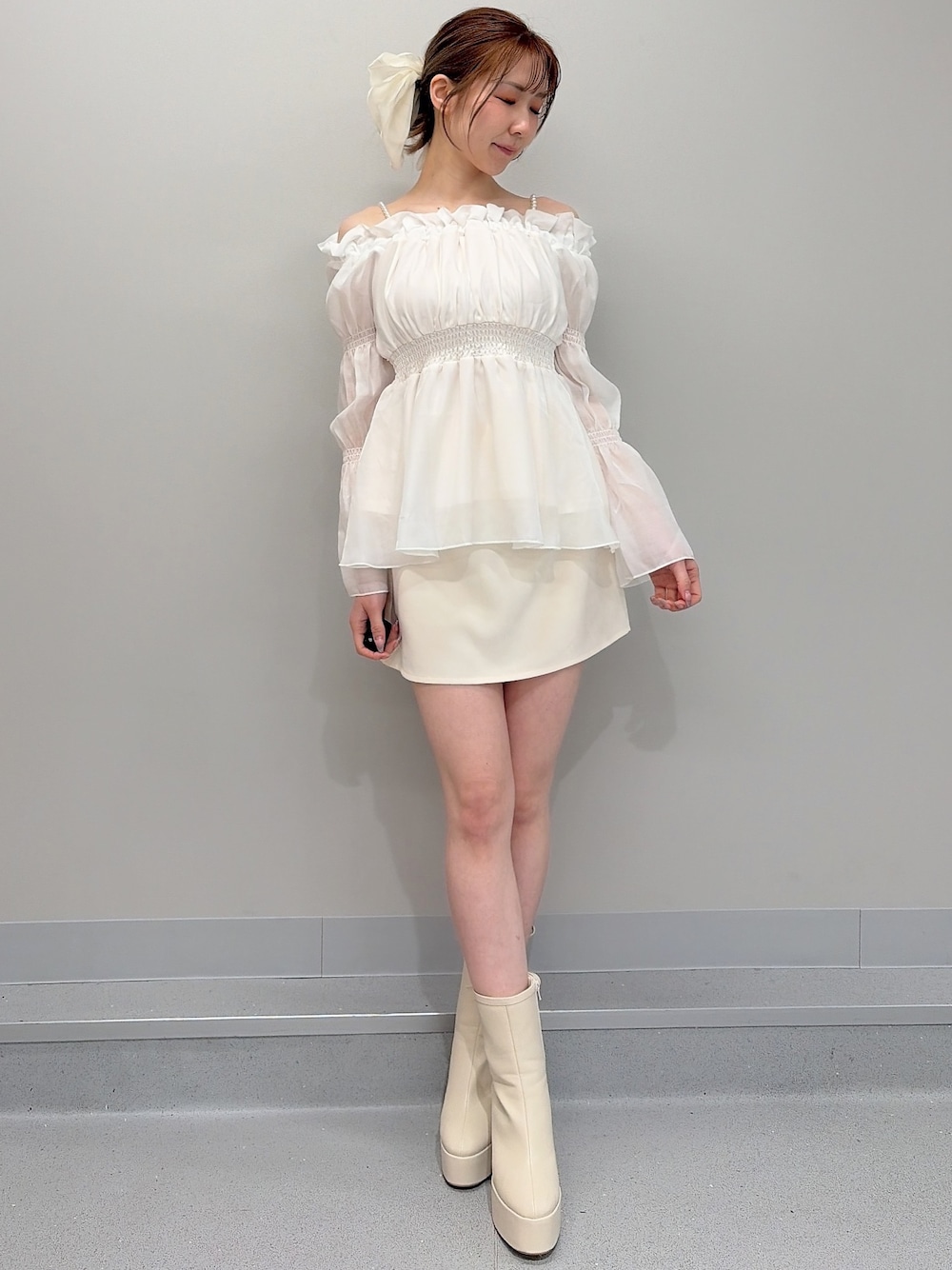 ホワイト系のブーツ、ホワイト系のシャツ/ブラウス、ホワイト系のスカートを着用したレディースの冬コーディネートの1枚目の写真