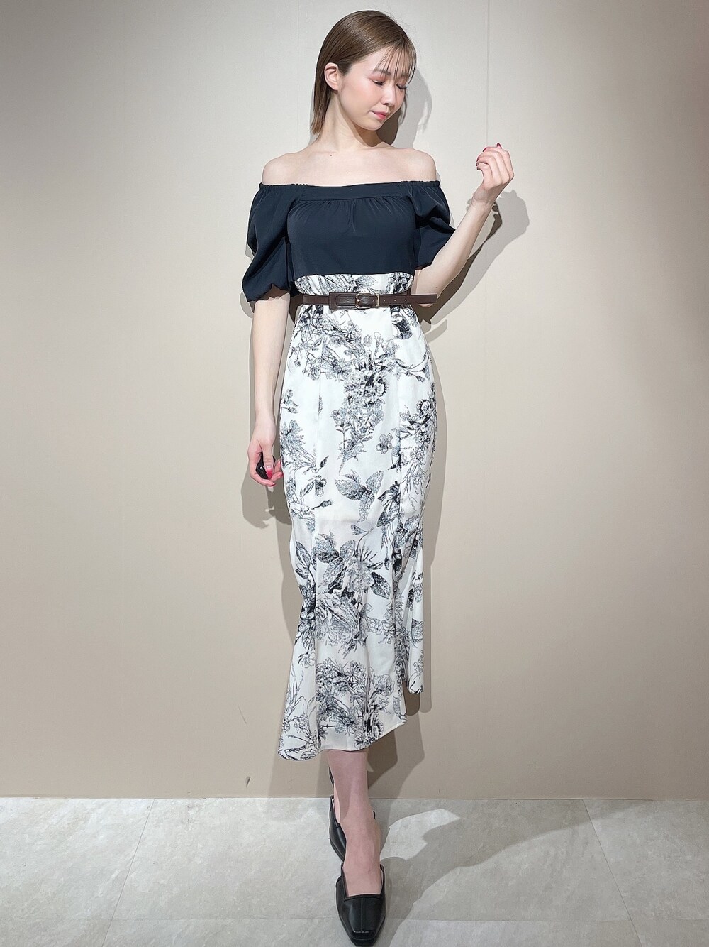 ブラック系のワンピース、ブラック系のパンプス、ブラウン系のベルトを着用したレディースの春コーディネートの1枚目の写真