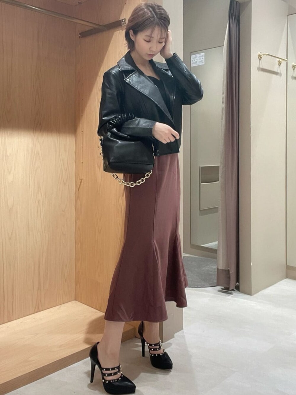 ブラック系のライダースジャケット、ブラック系のパンプス、ブラック系のハンドバッグを着用したレディースの秋コーディネートの1枚目の写真