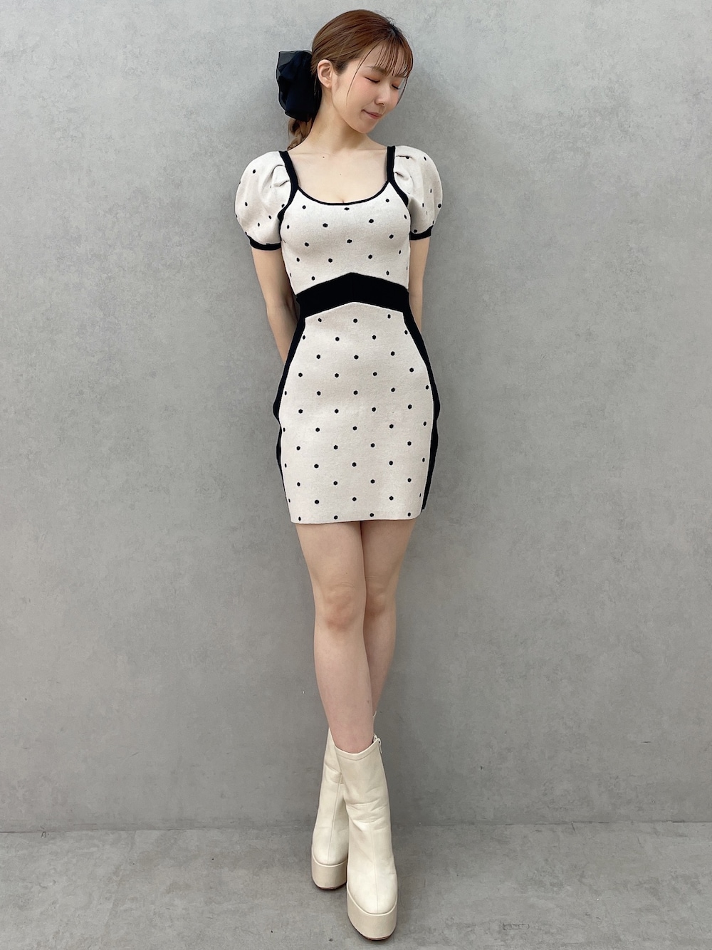 ブラック系のワンピース、ホワイト系のブーツ、ブラック系のバレッタ/ヘアクリップを着用したレディースの春コーディネートの1枚目の写真