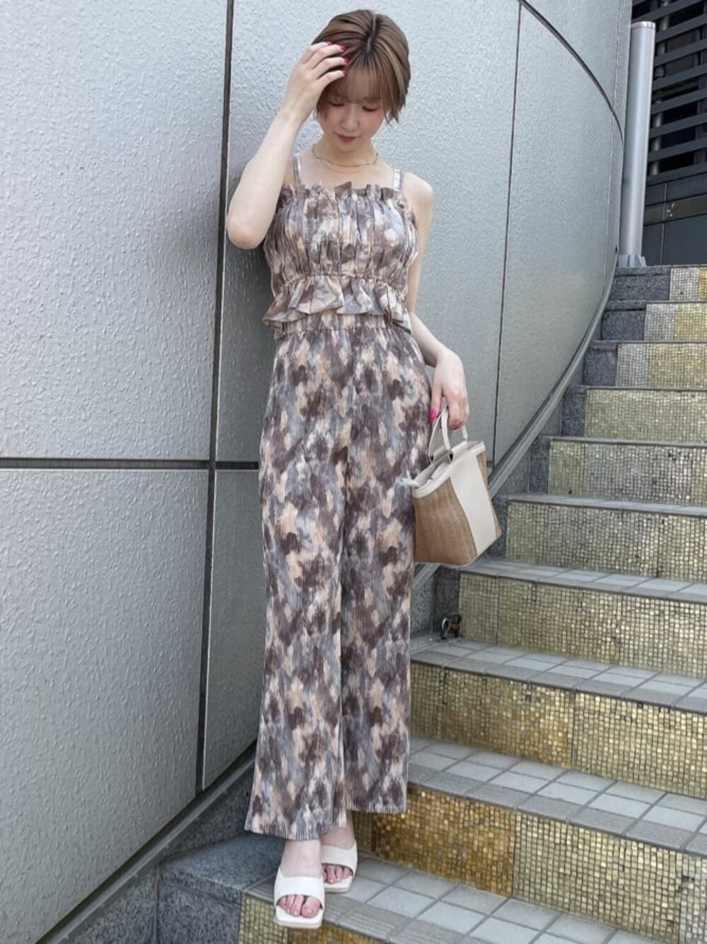 ベージュ系のハンドバッグ、ホワイト系のサンダル、ブルー系のその他パンツを着用したレディースの夏コーディネートの1枚目の写真