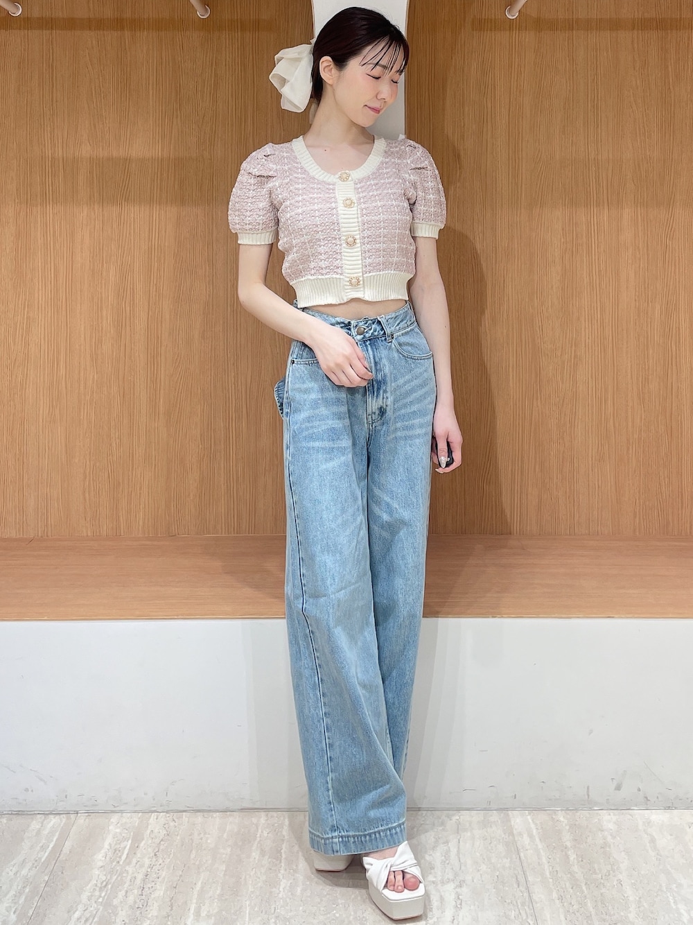 ピンク系のニット/セーター、ブルー系のデニムパンツ、ホワイト系のサンダルを着用したレディースの春コーディネートの1枚目の写真
