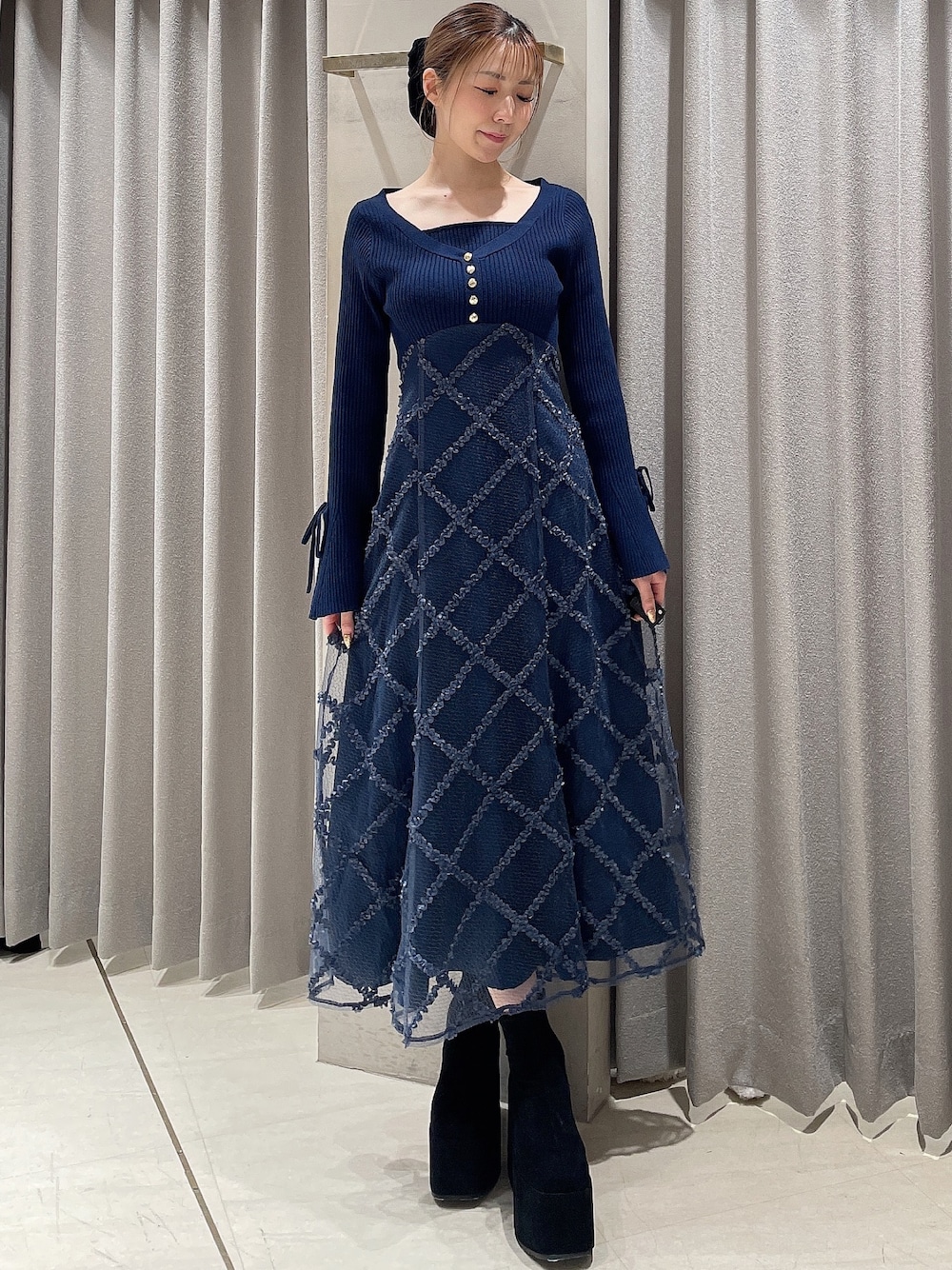 ブルー系のワンピース、ブラック系のブーツ、ブラック系のシュシュを着用したレディースの秋コーディネートの1枚目の写真