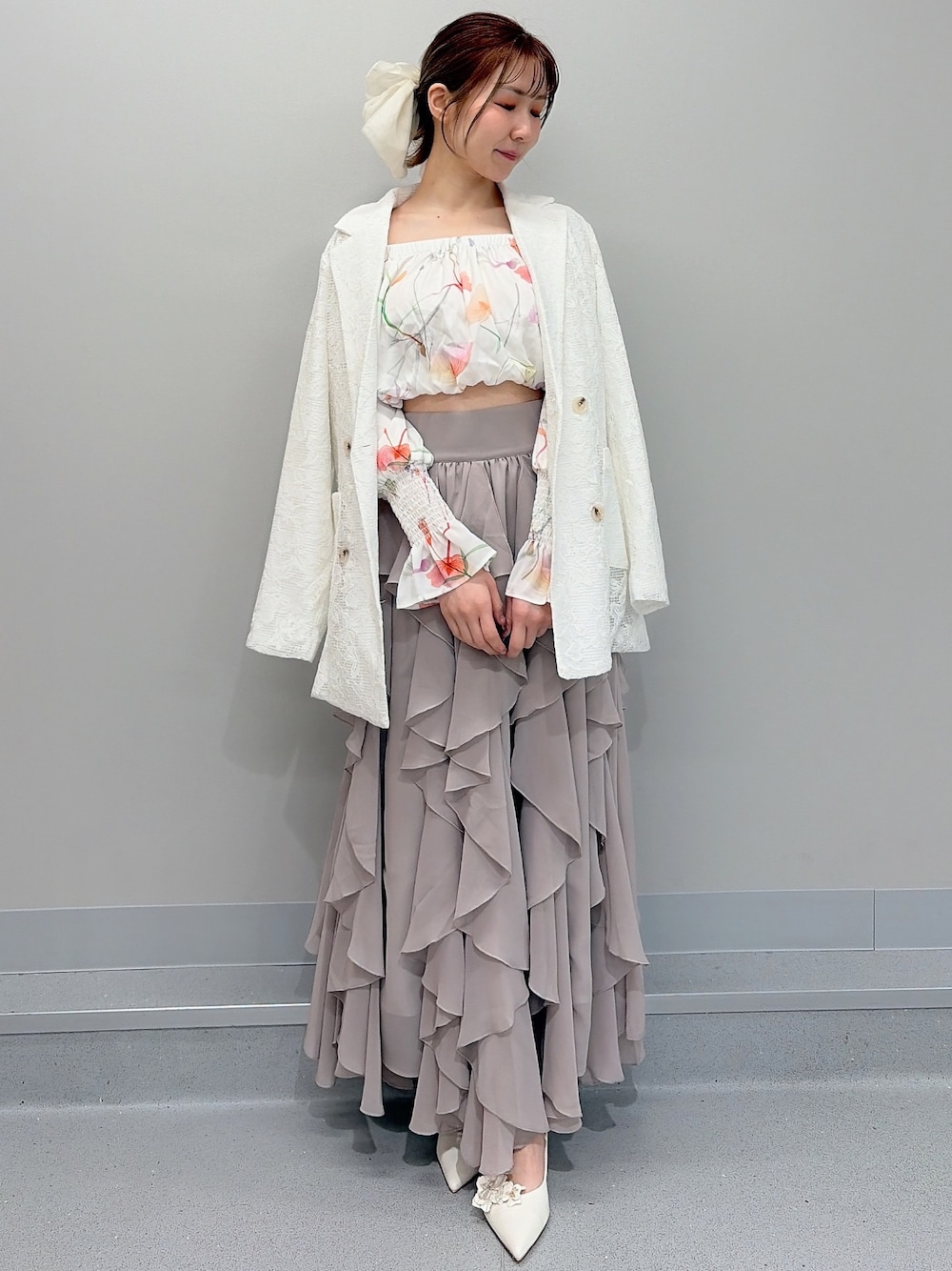 ホワイト系のテーラードジャケット、ホワイト系のシャツ/ブラウス、ベージュ系のスカートを着用したレディースの冬コーディネートの1枚目の写真