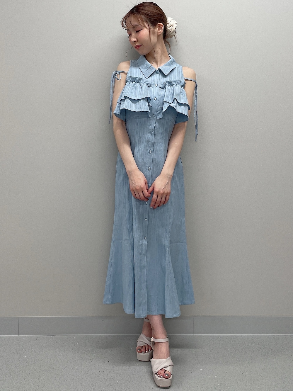 ブルー系のシャツワンピース、ベージュ系のサンダルを着用したレディースの春コーディネートの1枚目の写真