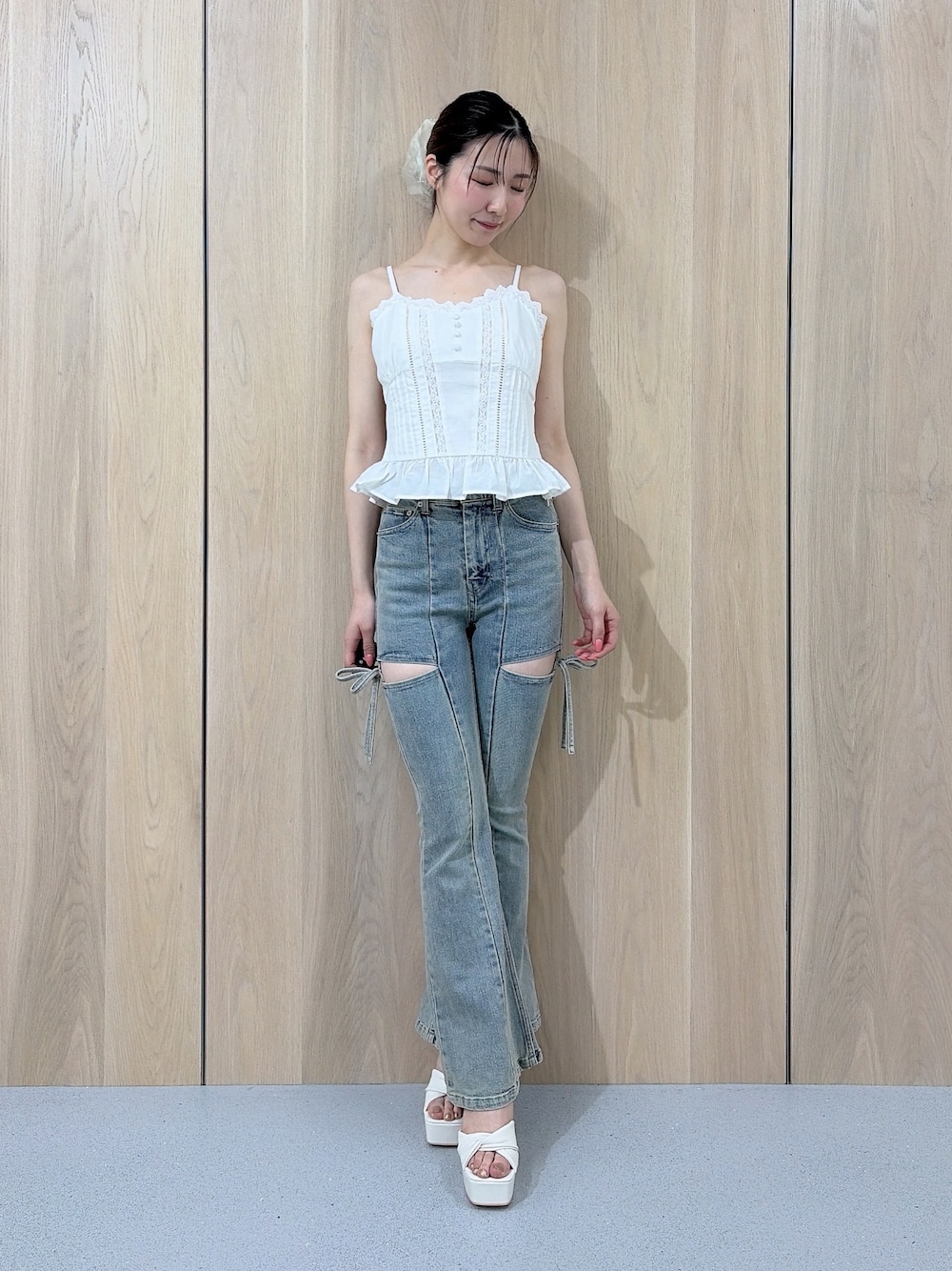 ホワイト系のキャミソール、ブルー系のデニムパンツ、ホワイト系のサンダルを着用したレディースの夏コーディネートの1枚目の写真