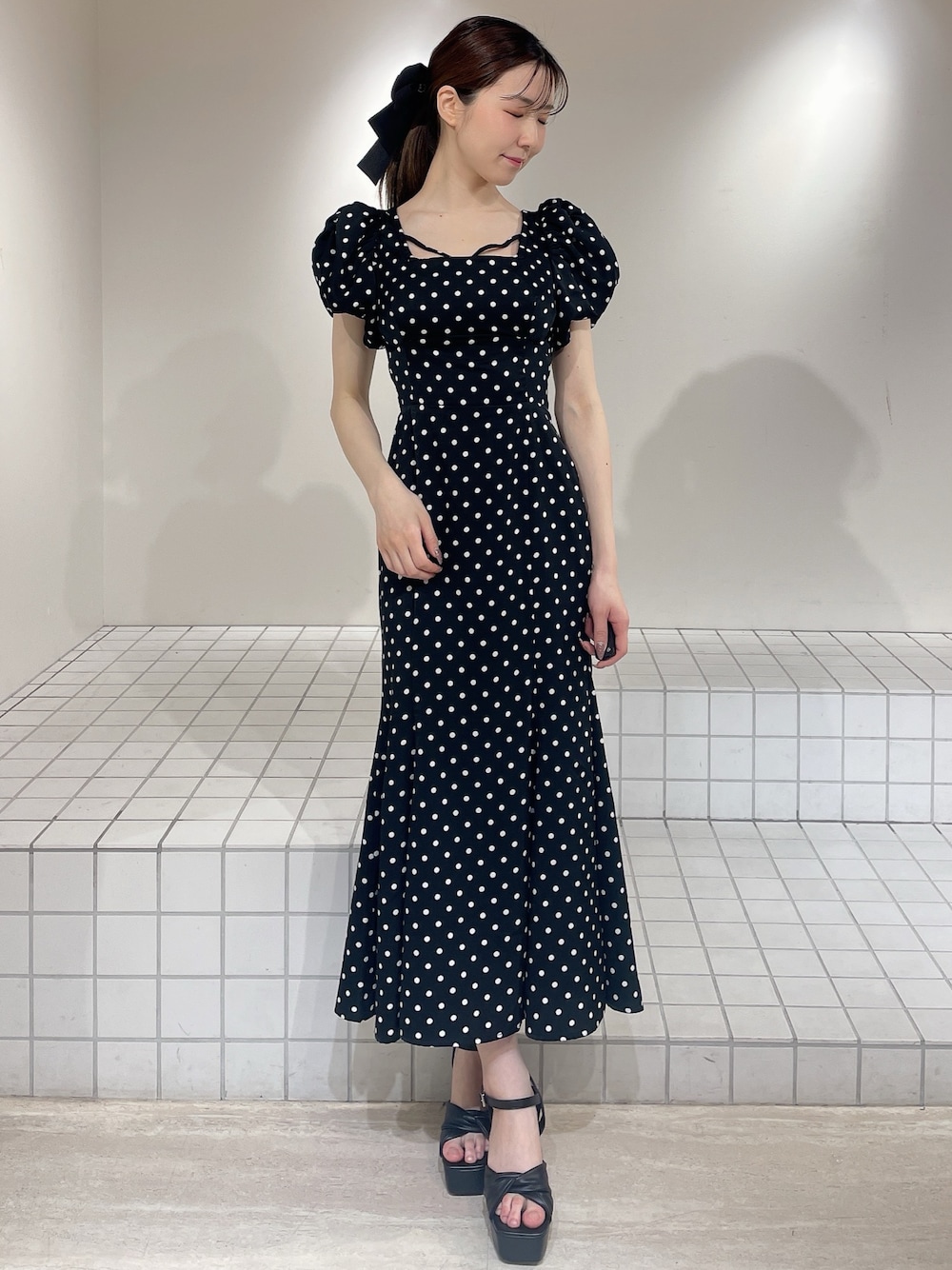 ブラック系のワンピース、ブラック系のサンダル、ブラック系のバレッタ/ヘアクリップを着用したレディースの春コーディネートの1枚目の写真