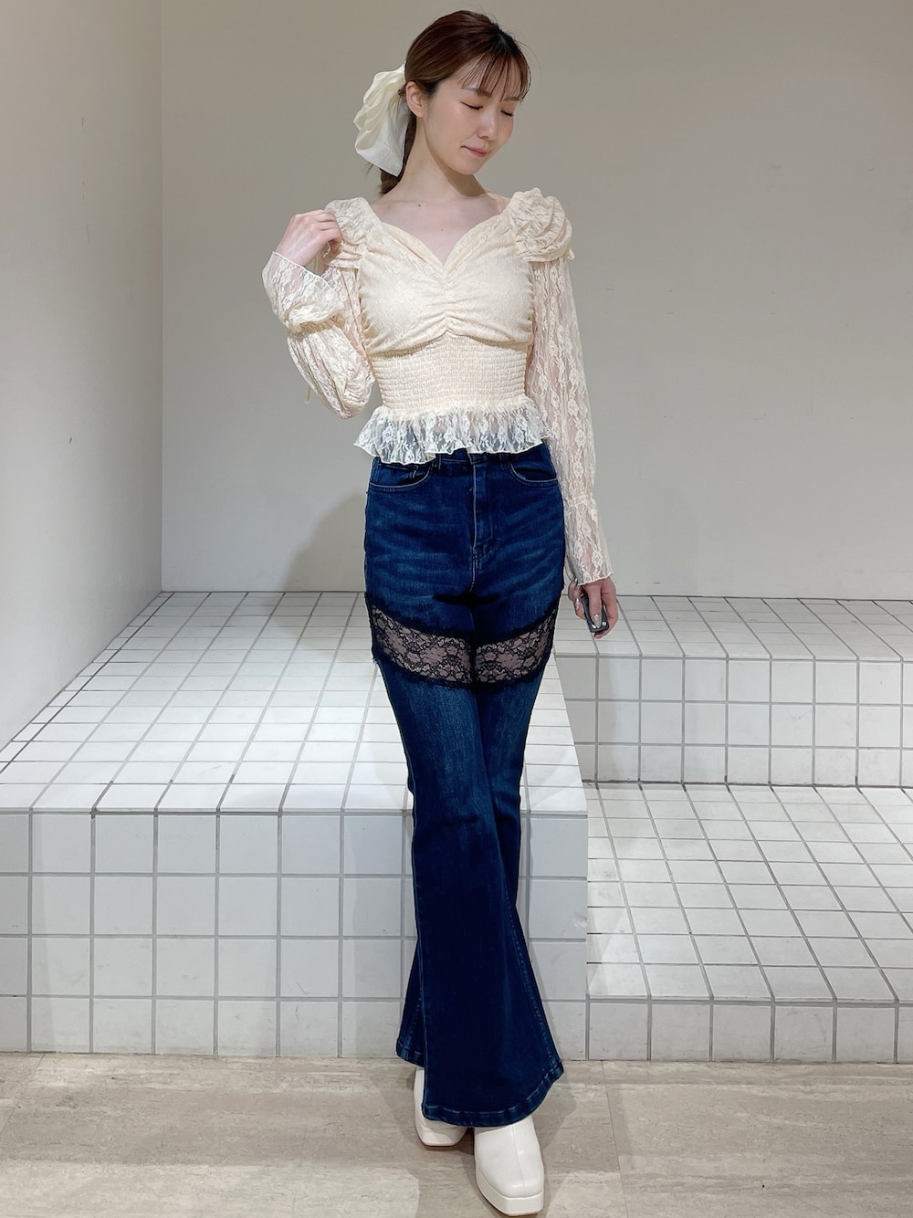 オレンジ系のシャツ/ブラウス、ブルー系のデニムパンツ、ホワイト系のブーツを着用したレディースの春コーディネートの1枚目の写真