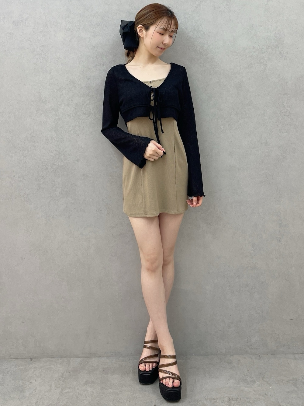 ベージュ系のワンピース、ブラック系のサンダル、ブラック系のバレッタ/ヘアクリップを着用したレディースの春コーディネートの1枚目の写真