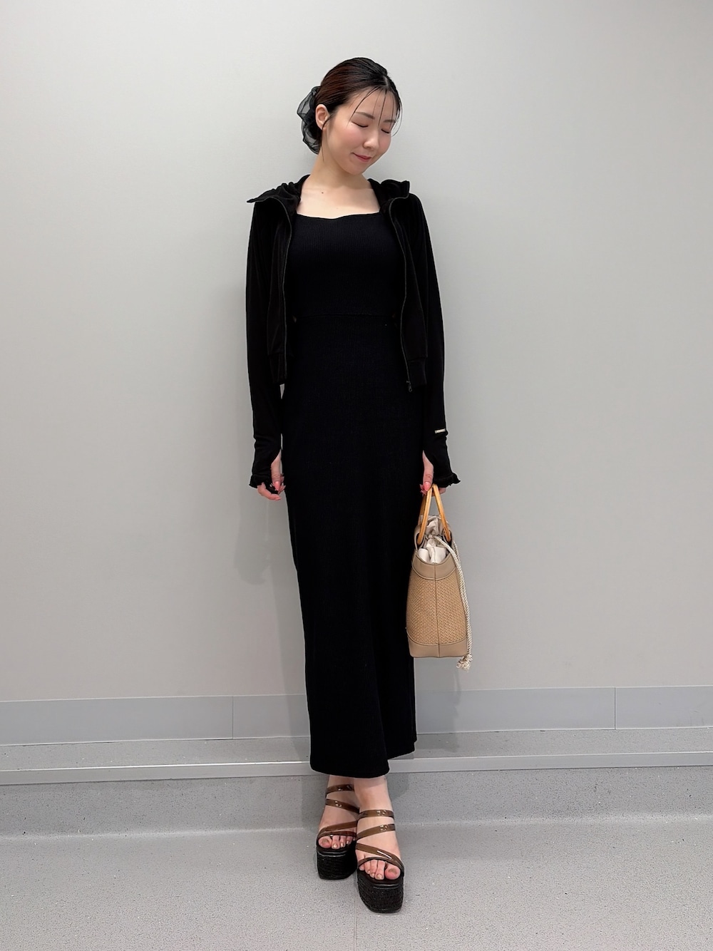 ブラック系のワンピース、ブラック系のTシャツ/カットソー、ベージュ系のハンドバッグを着用したレディースの夏コーディネートの1枚目の写真