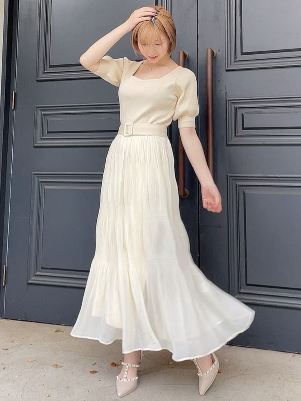 ホワイト系のワンピース、ベージュ系のパンプス、ホワイト系のハットを着用したレディースの春コーディネートの1枚目の写真