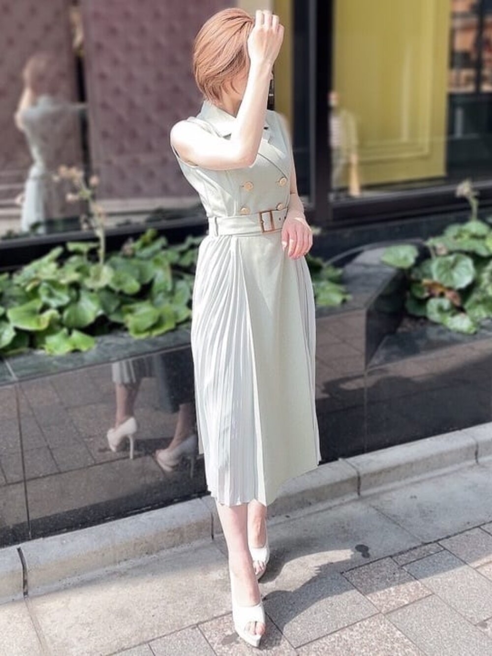 ホワイト系のパンプス、グリーン系のワンピース、ゴールド系のネックレスを着用したレディースの春コーディネートの1枚目の写真