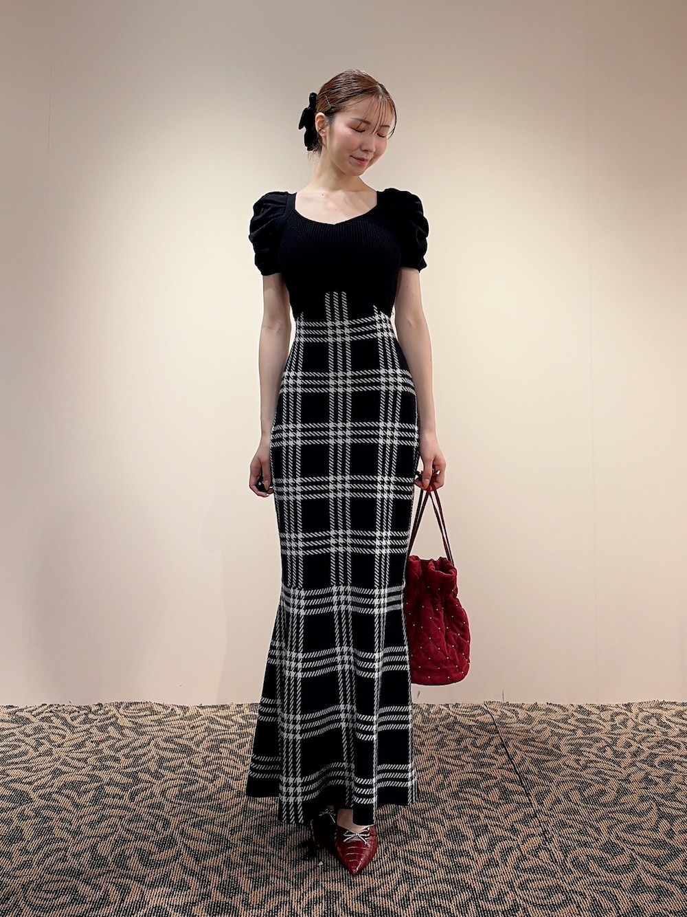 ブラック系のワンピース、レッド系のハンドバッグ、ブラック系のバレッタ/ヘアクリップを着用したレディースの夏コーディネートの1枚目の写真