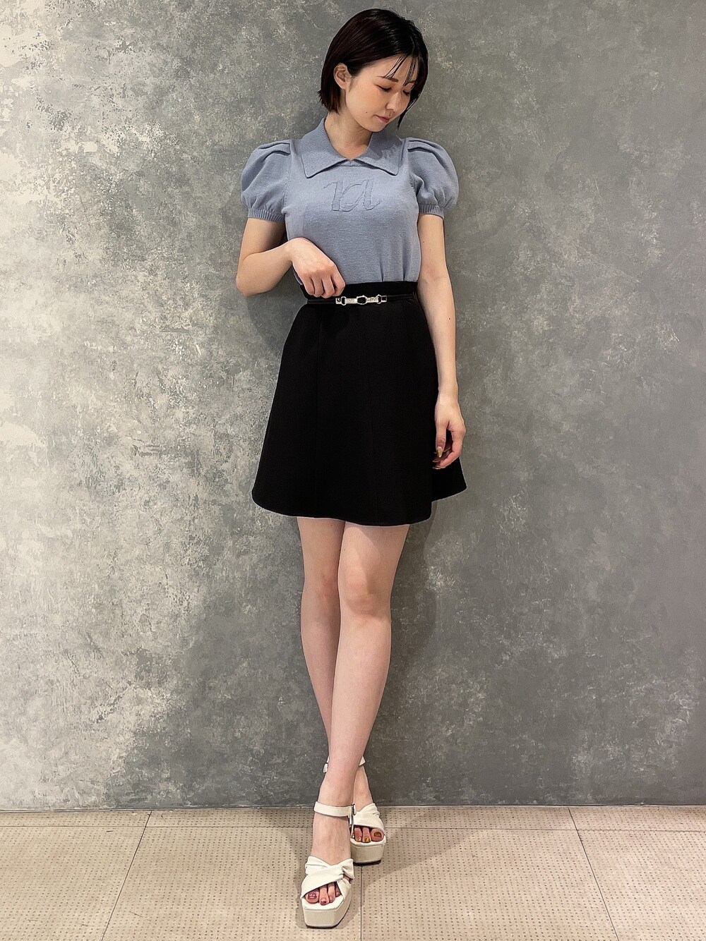 ホワイト系のサンダル、ブルー系のニット/セーター、ブラック系のスカートを着用したレディースの夏コーディネートの1枚目の写真